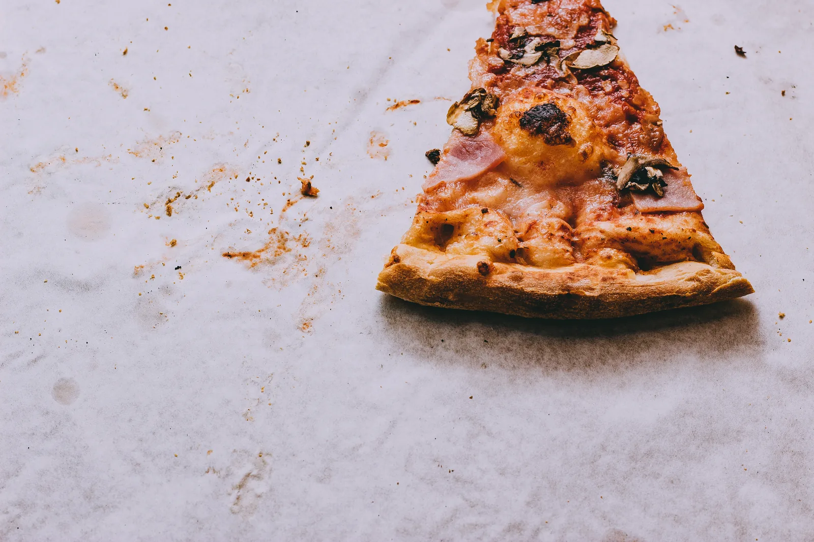 A single slice of pizza on paper